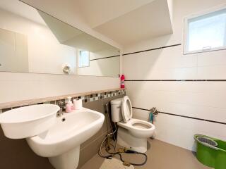 Clean modern bathroom with large mirror and white fixtures