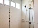 Shower area in bathroom with window and water heater