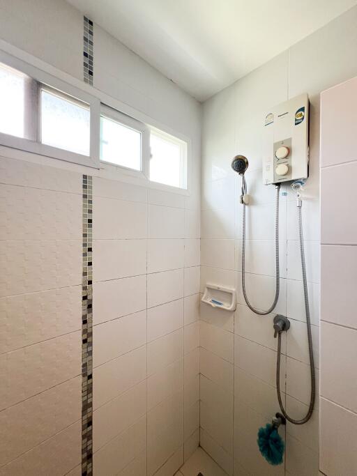 Shower area in bathroom with window and water heater