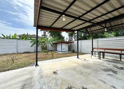 Covered outdoor space with a small shed and concrete flooring