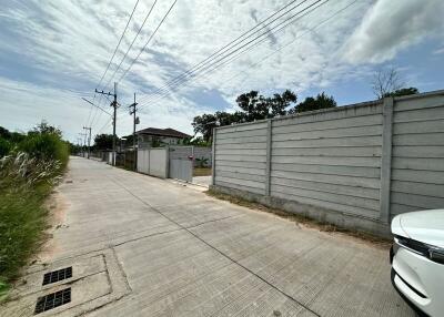 Street view with concrete fence and house in background