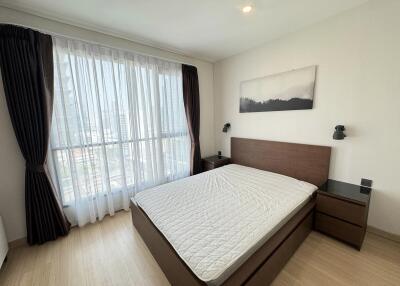 Modern bedroom with large window and wooden furniture