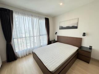 Modern bedroom with large window and wooden furniture