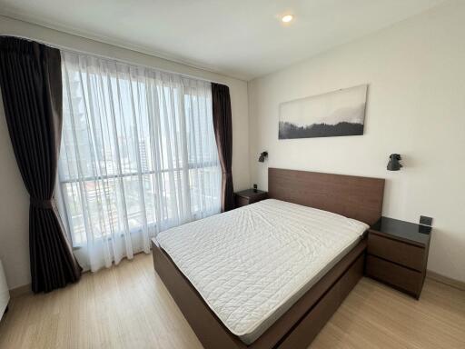 Modern bedroom with large window and wooden furniture