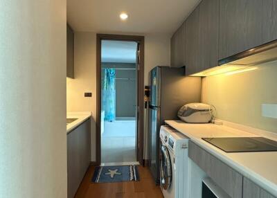 A modern kitchen with wooden flooring, light gray cabinets, and various appliances