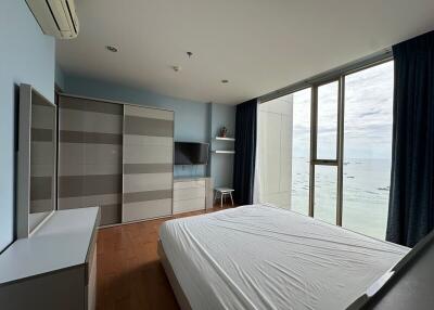 Spacious bedroom with large windows and ocean view