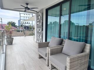 Spacious balcony with seating and ceiling fan