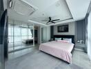 Spacious modern bedroom with a large bed, mirrored wardrobe, and ceiling fan