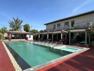 Outdoor pool area with lounge chairs and building in the background