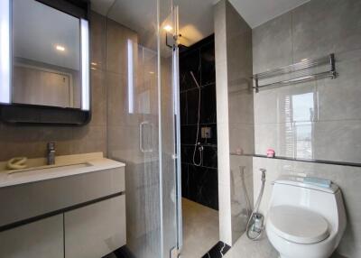 Modern bathroom with mirror, vanity, shower, and toilet