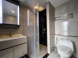 Modern bathroom with mirror, vanity, shower, and toilet