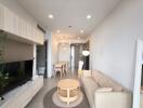 Modern living room with beige sofa and dining area in the background