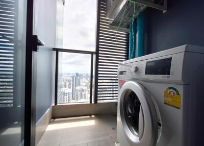 Utility room with washing machine and city view