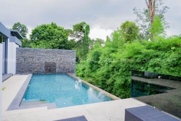 Modern outdoor swimming pool with lush greenery