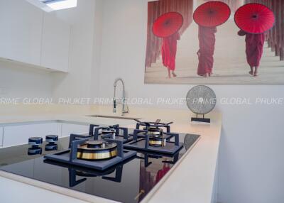 Modern kitchen with stove and cultural artwork