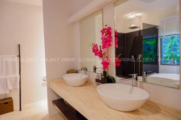 Modern bathroom with double sinks and decorative orchid