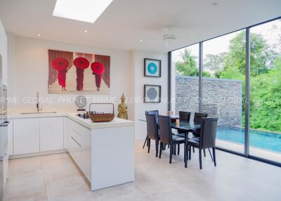 Modern kitchen area with dining table and pool view