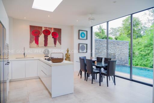 Modern kitchen area with dining table and pool view