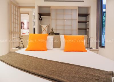 Cozy bedroom with bright orange pillows and modern decor