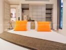 Cozy bedroom with bright orange pillows and modern decor