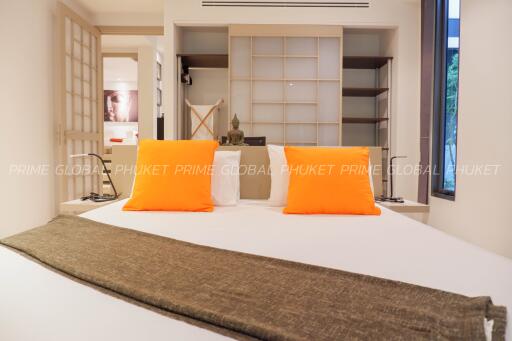 Cozy bedroom with bright orange pillows and modern decor