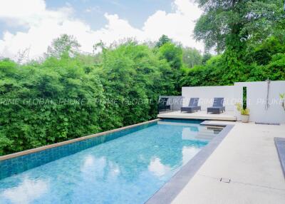 Luxurious swimming pool with seating area and lush greenery