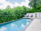 Luxurious swimming pool with seating area and lush greenery