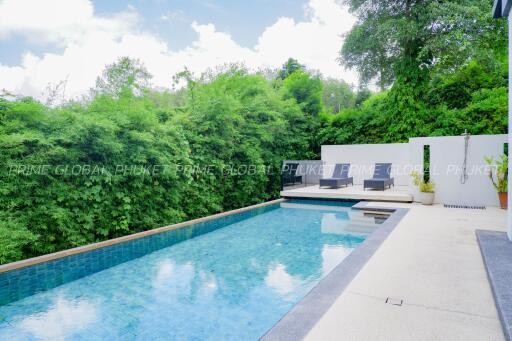 Luxurious swimming pool with seating area and lush greenery