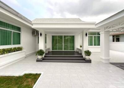 Front view of a modern house with tiled flooring and green windows