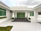 Front view of a modern house with tiled flooring and green windows