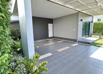 Empty garage space with tiled flooring and landscaped garden