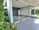 Empty garage space with tiled flooring and landscaped garden