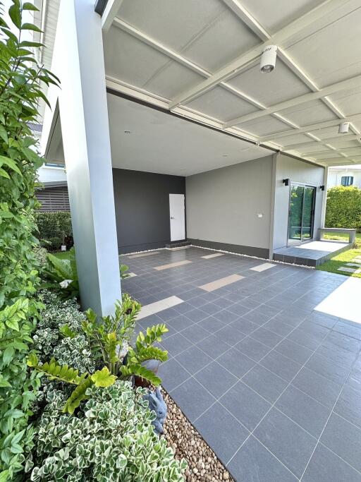 Empty garage space with tiled flooring and landscaped garden
