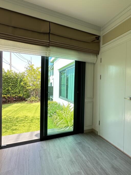 Bedroom with sliding glass door leading to a garden