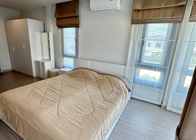 Well-lit bedroom with a large bed, air conditioning, and ample natural light.