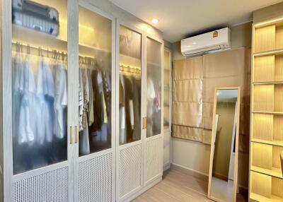 Spacious walk-in wardrobe with wooden flooring and modern lighting