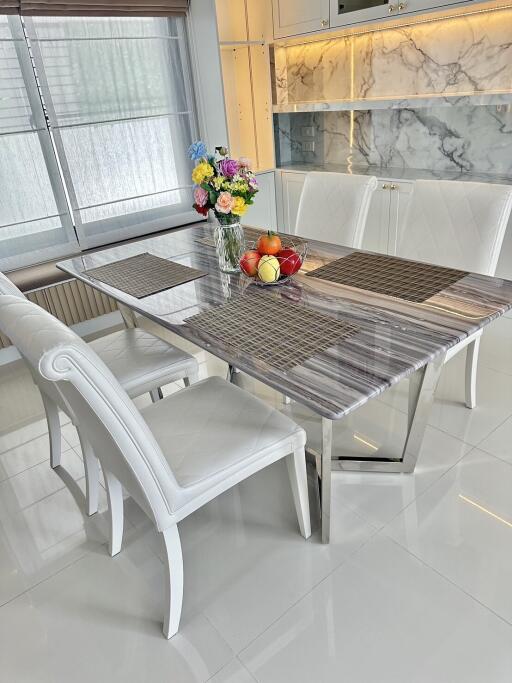 Elegant dining area with a marble table and white chairs