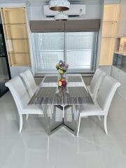 Modern dining room with white chairs and a marble table