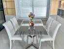 Modern dining room with white chairs and a marble table