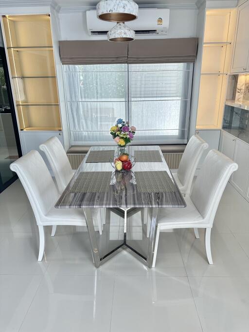 Modern dining room with white chairs and a marble table