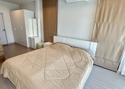 modern bedroom with beige bedding and air conditioning