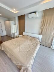 modern bedroom with beige bedding and air conditioning