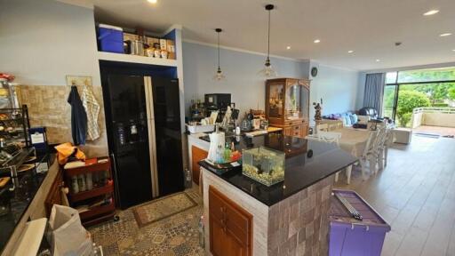 Modern kitchen with black refrigerator and island countertop adjacent to a dining area