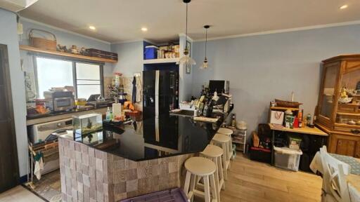 Modern kitchen with black countertop and bar stools