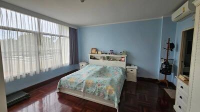 Cozy bedroom with a large window and wooden floor