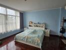 Cozy bedroom with a large window and wooden floor