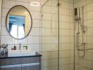 Modern bathroom with mirror, wash basin, and shower enclosure