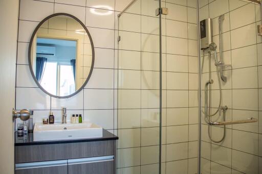 Modern bathroom with mirror, wash basin, and shower enclosure