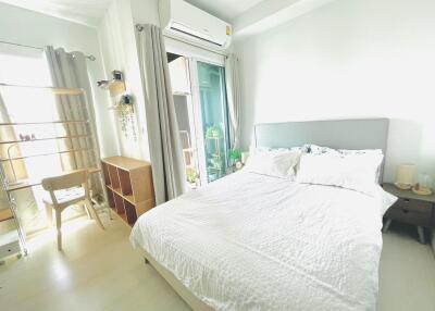 Bright and cozy bedroom with a large bed, air conditioning, and a balcony.