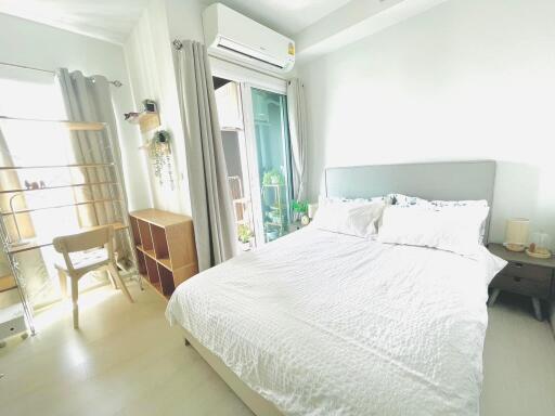 Bright and cozy bedroom with a large bed, air conditioning, and a balcony.